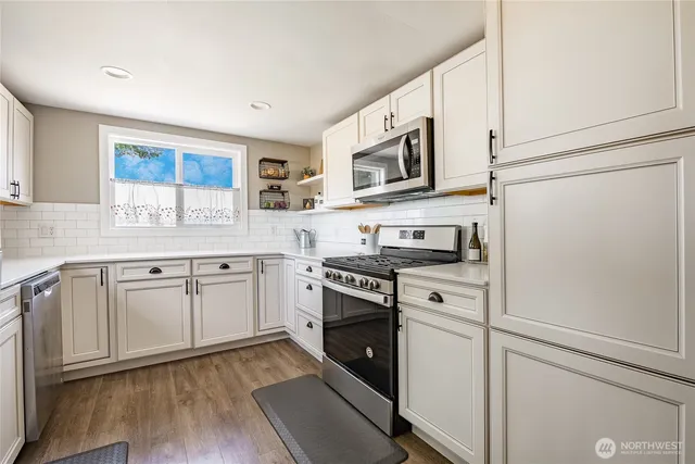 a kitchen with granite countertop white cabinets and white appliances