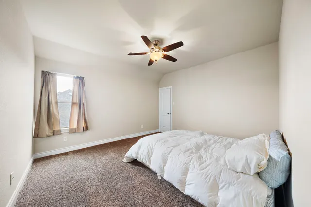 a bedroom with a bed and a ceiling fan