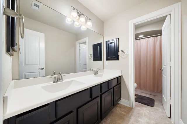 a bathroom with a double vanity sink and mirror