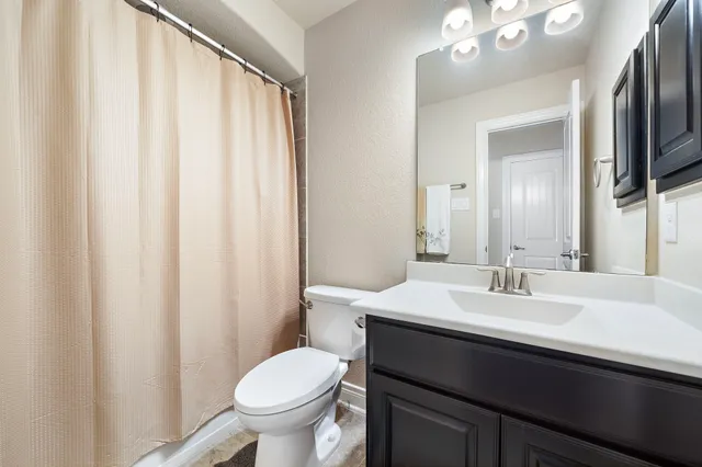 a bathroom with a sink a toilet and a mirror