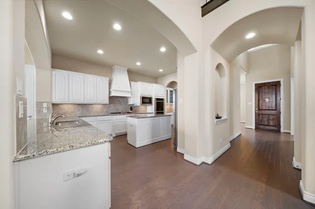 a kitchen with kitchen island a sink stainless steel appliances and cabinets