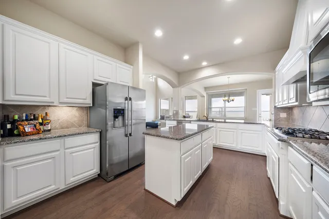 a kitchen with white cabinets and white appliances