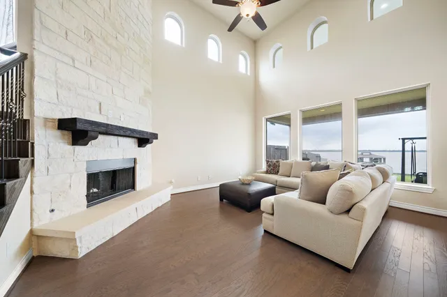 a living room with furniture a fireplace and a ceiling fan