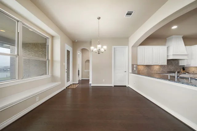 a view of an empty room with window and cabinet