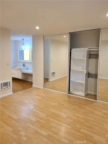 a view of empty room with wooden floor and cabinet