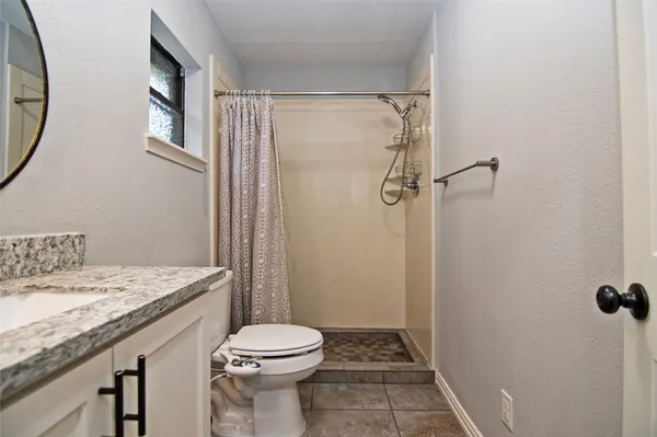 a bathroom with a granite countertop sink toilet and shower