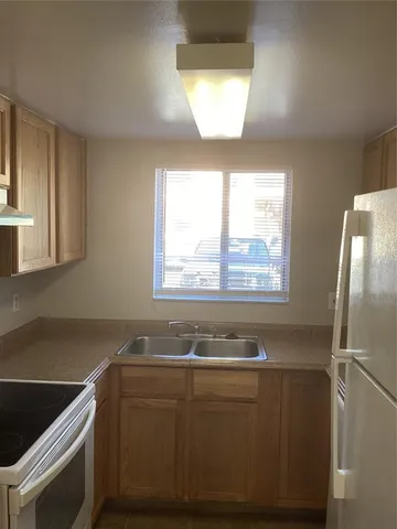 a view of kitchen with granite countertop cabinets appliances and a sink
