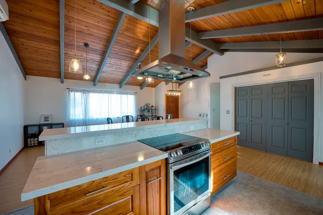 a kitchen with stainless steel appliances granite countertop a sink a stove and a wooden floors