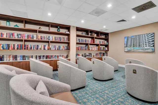 a front view of multi story residential apartment building with yard and retail shops