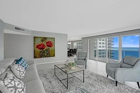 a living room with furniture large window and a flat screen tv