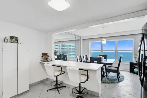 a room with a table chairs and a refrigerator