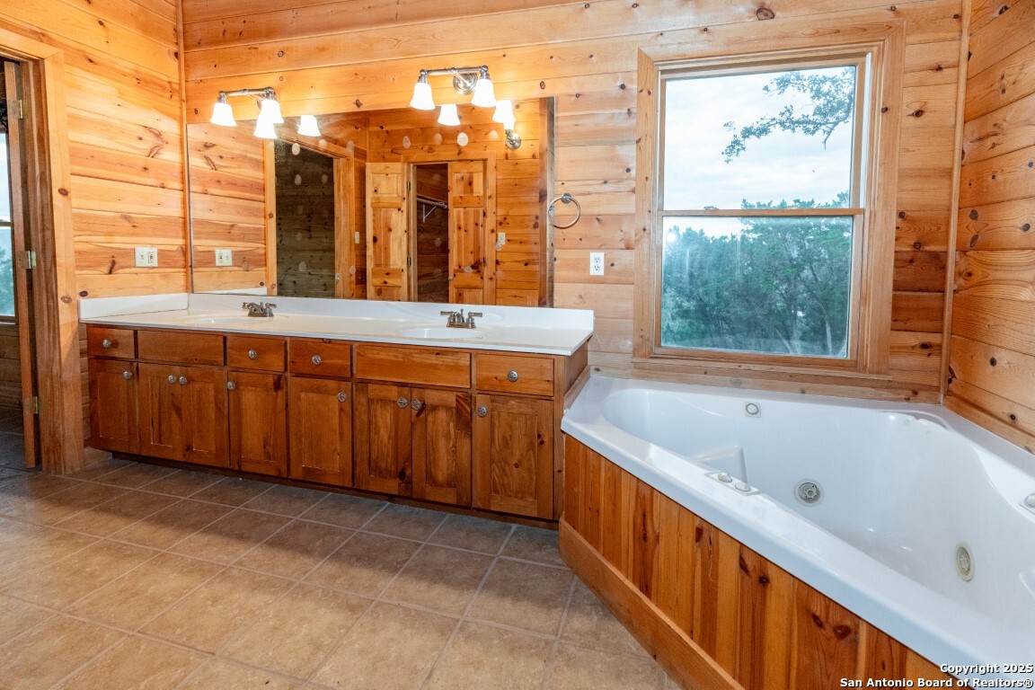 599 Mountain View Road Utopia, TX 78884 - Photo 11 of 38 a bathroom with a tub sink and double vanity