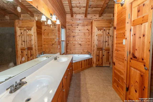 a bathroom with a tub sink shower and a mirror