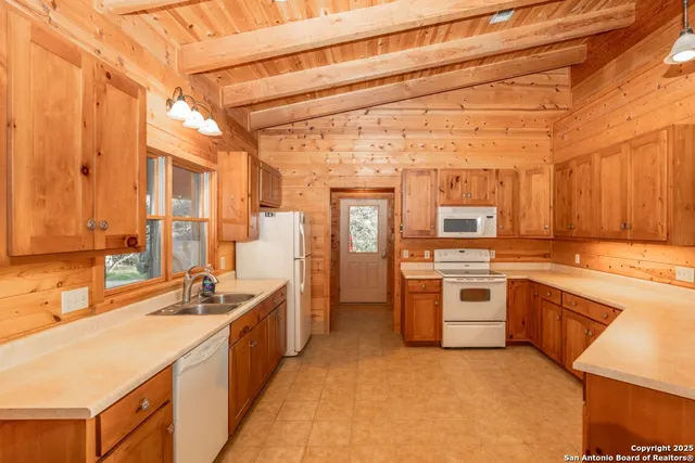 a large kitchen with a sink and stainless steel appliances