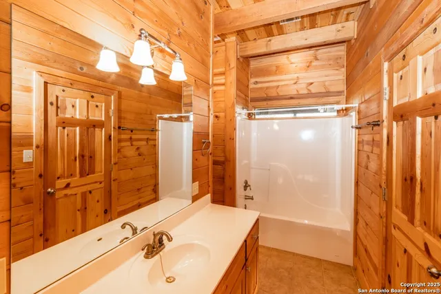 a bathroom with a tub sink and shower