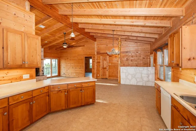 a large kitchen with stainless steel appliances granite countertop a sink and cabinets