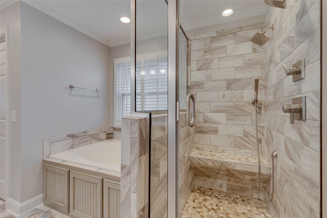 302 Wild Rice Drive Simpsonville, SC 29681 - Photo 28 of 44 Tiled walk-in shower with bench seating and adjacent soaking tub.