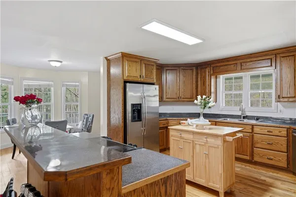 a kitchen with stainless steel appliances granite countertop a sink a stove and a refrigerator
