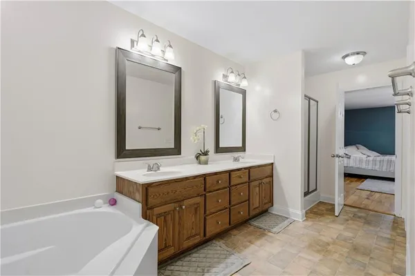 a bathroom with a tub sink and mirror