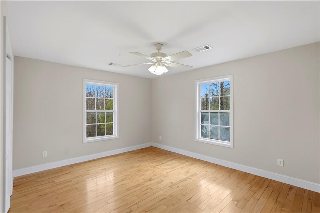 262 Iron Hill Road Taylorsville, GA 30178 - Photo 27 of 38 an empty room with windows and ceiling fan