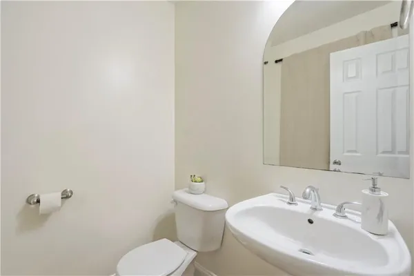 a bathroom with a sink a toilet and mirror