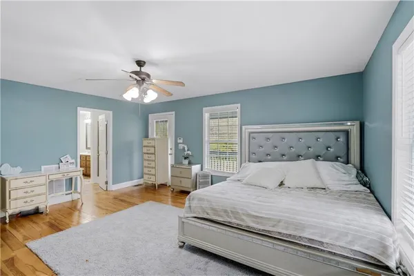 a bedroom with a large bed and ceiling fan
