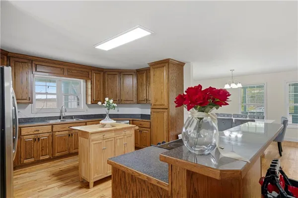 a view of a kitchen with kitchen island stainless steel appliances a sink and cabinets