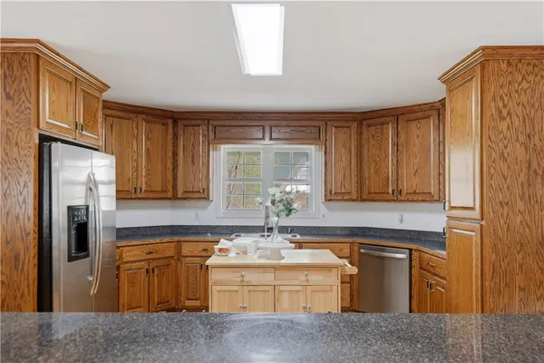 a kitchen with stainless steel appliances granite countertop a sink a stove and refrigerator