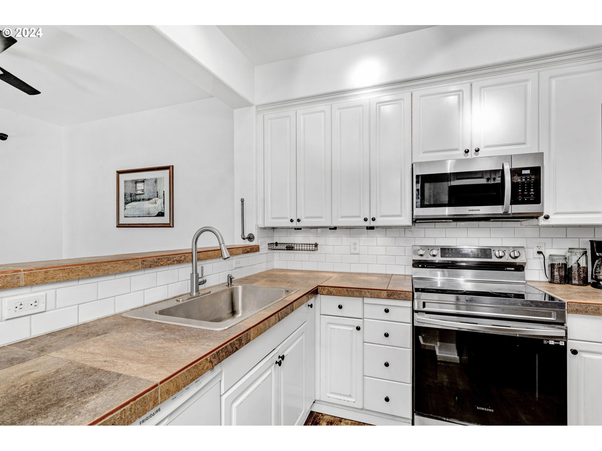 4083 Southwest 182nd Place Beaverton, OR 97078 - Photo 15 of 33 a kitchen with stainless steel appliances granite countertop a sink dishwasher a stove and a microwave oven with cabinets