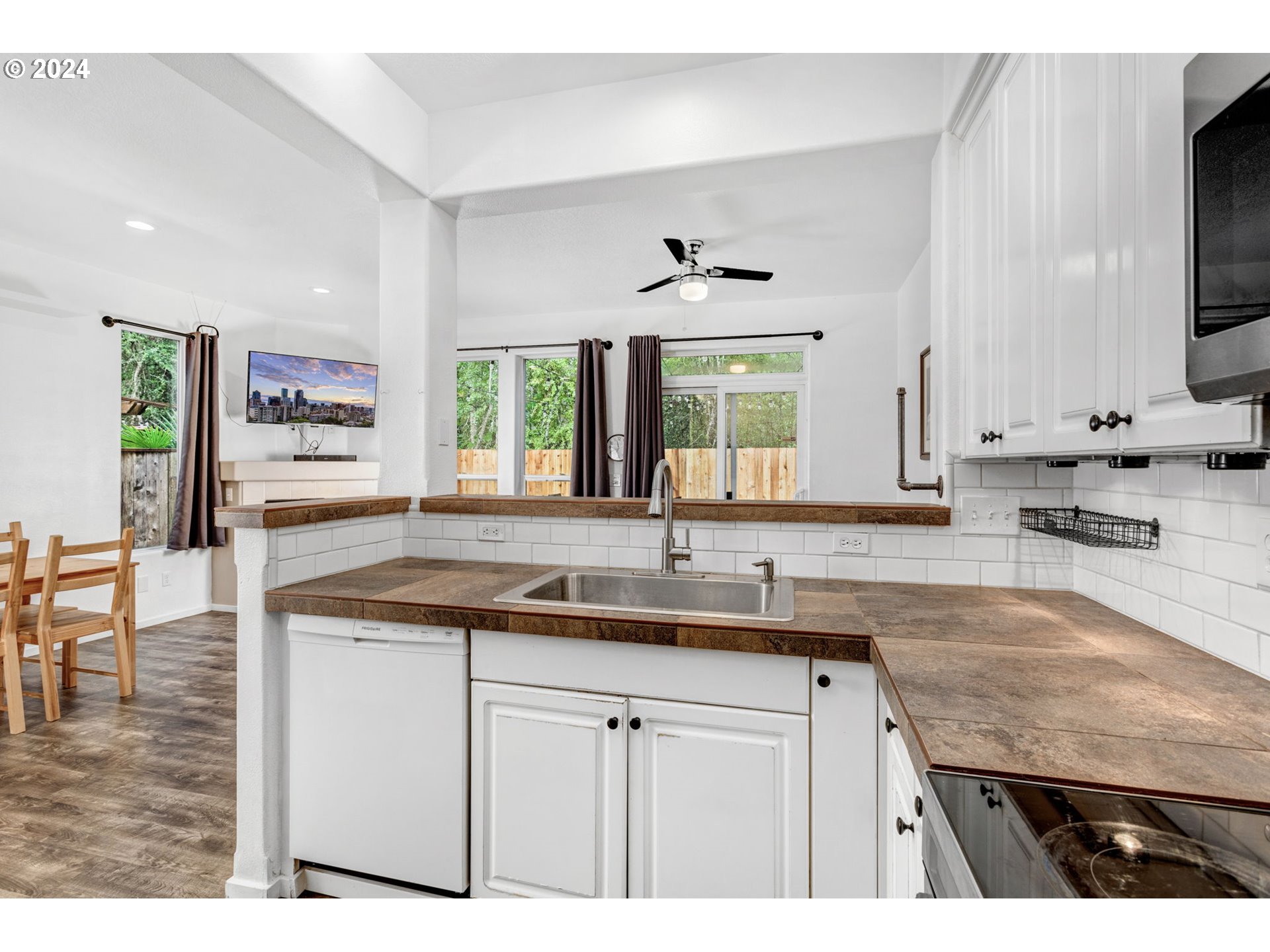 4083 Southwest 182nd Place Beaverton, OR 97078 - Photo 16 of 33 a kitchen with a sink dishwasher a stove and cabinets with wooden floor