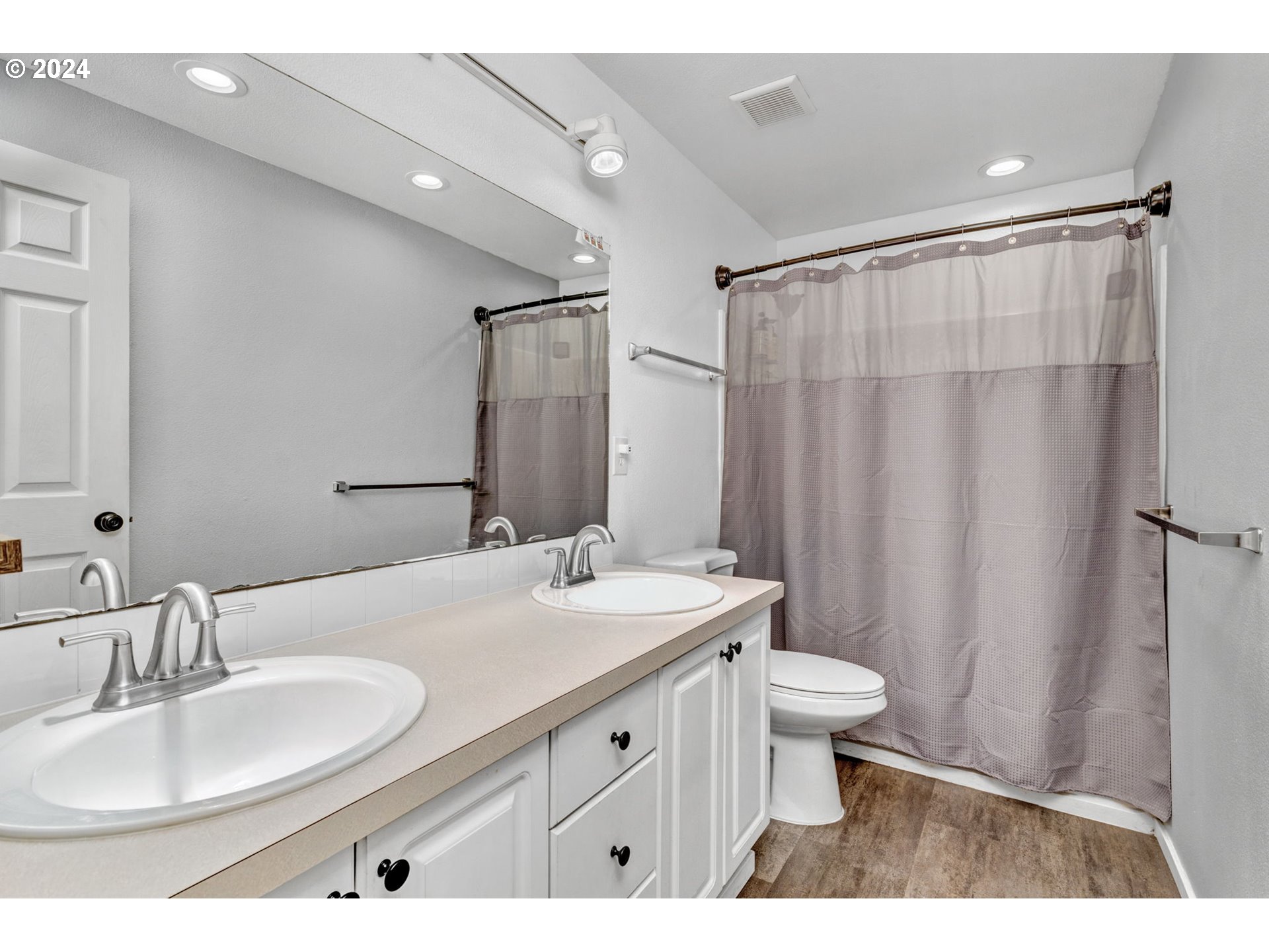 4083 Southwest 182nd Place Beaverton, OR 97078 - Photo 22 of 33 a bathroom with a sink a toilet a mirror and shower curtain