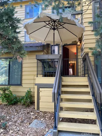 a view of a patio with a table and chairs under an umbrella