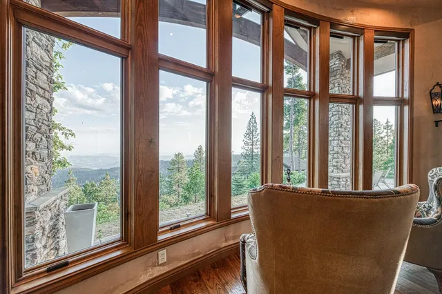 a room with chandelier pool table and windows