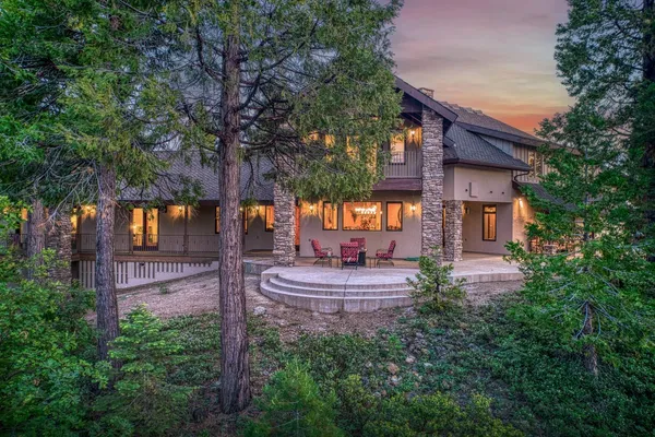 a house view with a sitting space fire pit and outdoor space