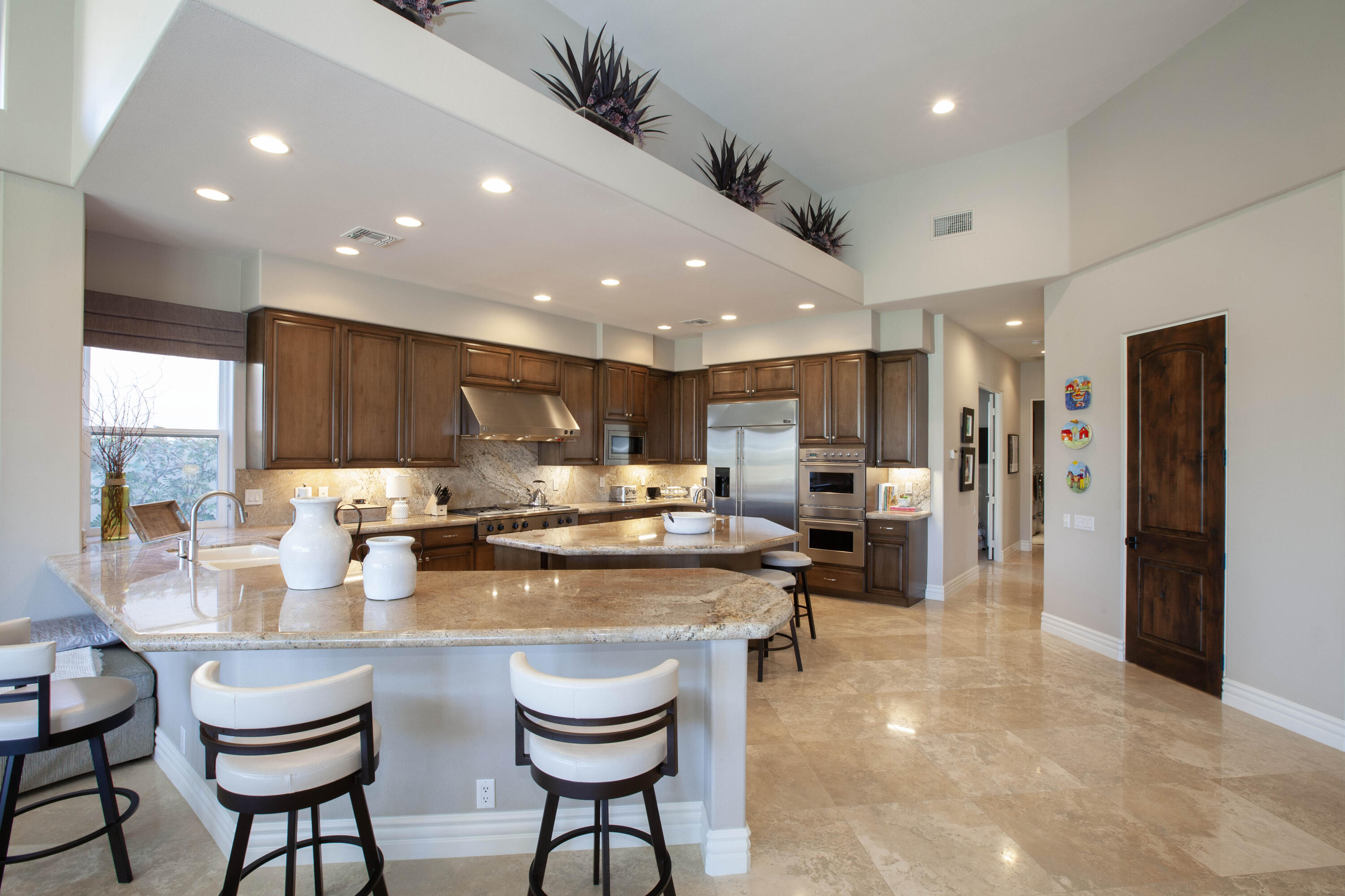 49487 Vía Conquistador La Quinta, CA 92253 - Photo 25 of 49 a kitchen with a dining table chairs stove refrigerator and cabinets