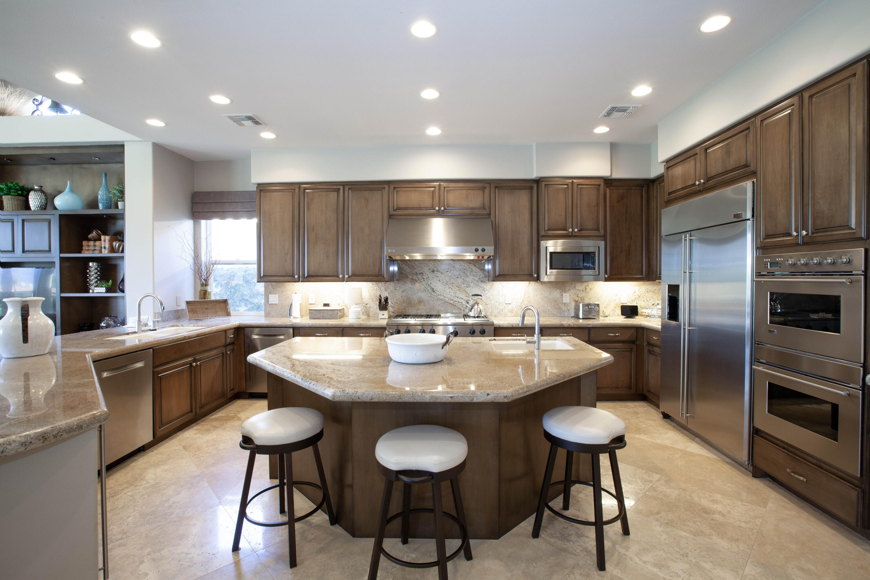 49487 Vía Conquistador La Quinta, CA 92253 - Photo 26 of 49 a kitchen with kitchen island granite countertop lots of counter top space and stainless steel appliances