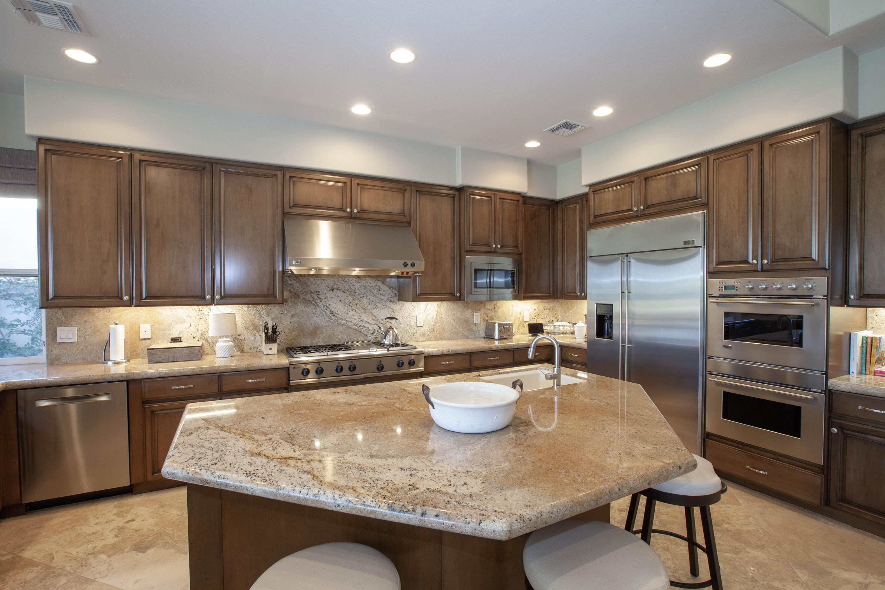 49487 Vía Conquistador La Quinta, CA 92253 - Photo 27 of 49 a kitchen with kitchen island granite countertop a sink and refrigerator