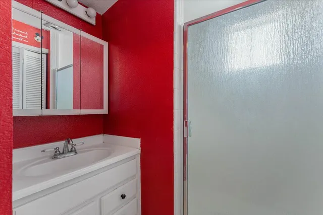 a bathroom with a sink a mirror and a shower