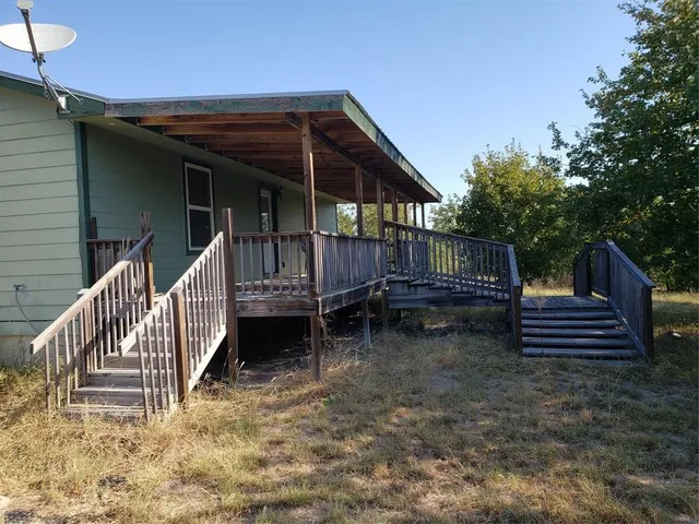 a view of wooden house with a yard and wooden fence