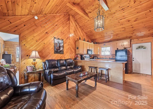 a living room with furniture and a dining table with wooden floor