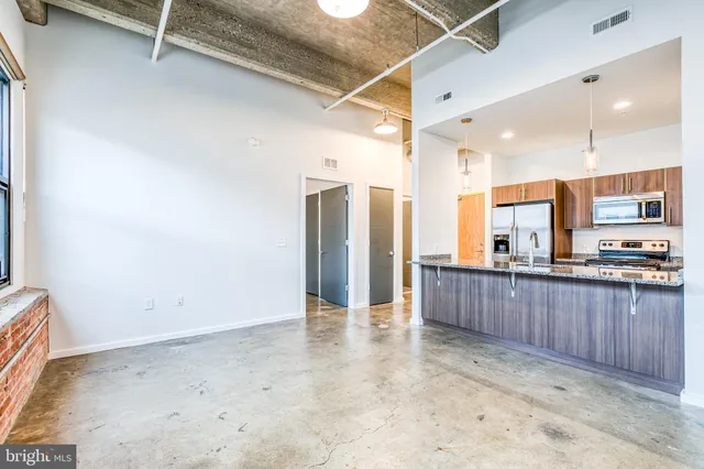 a view of a kitchen with stainless steel appliances granite countertop a refrigerator and a sink