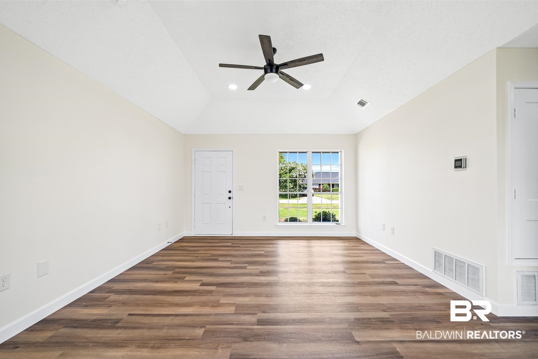 8921 Sherman Road Foley, AL 36535 - Photo 3 of 19 Unfurnished room with hardwood / wood-style floors, ceiling fan, and a raised ceiling