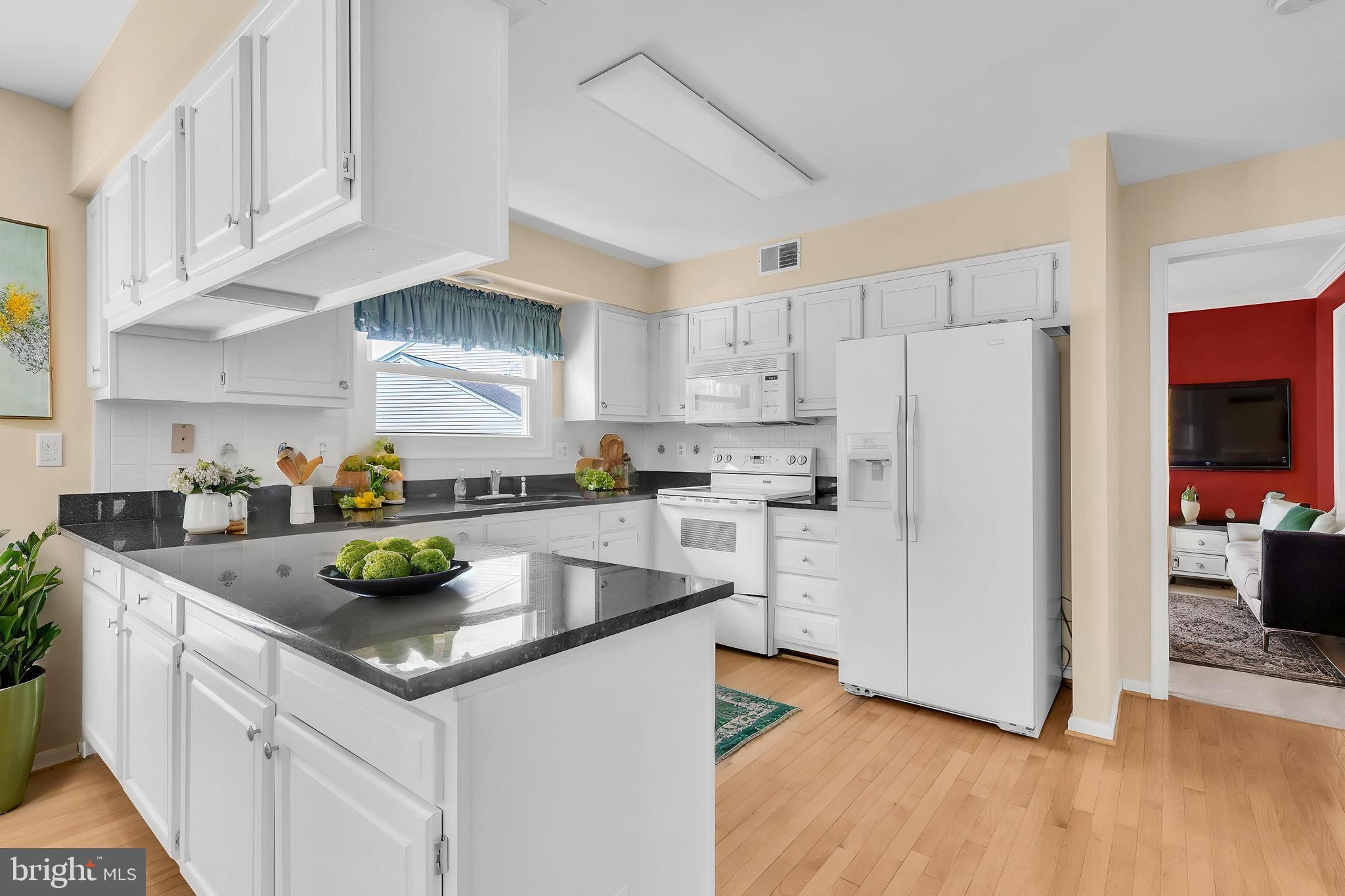 13988 Dancing Twig Drive Gainesville, VA 20155 - Photo 18 of 62 a kitchen with stainless steel appliances granite countertop a refrigerator a sink a stove a dining table and chairs
