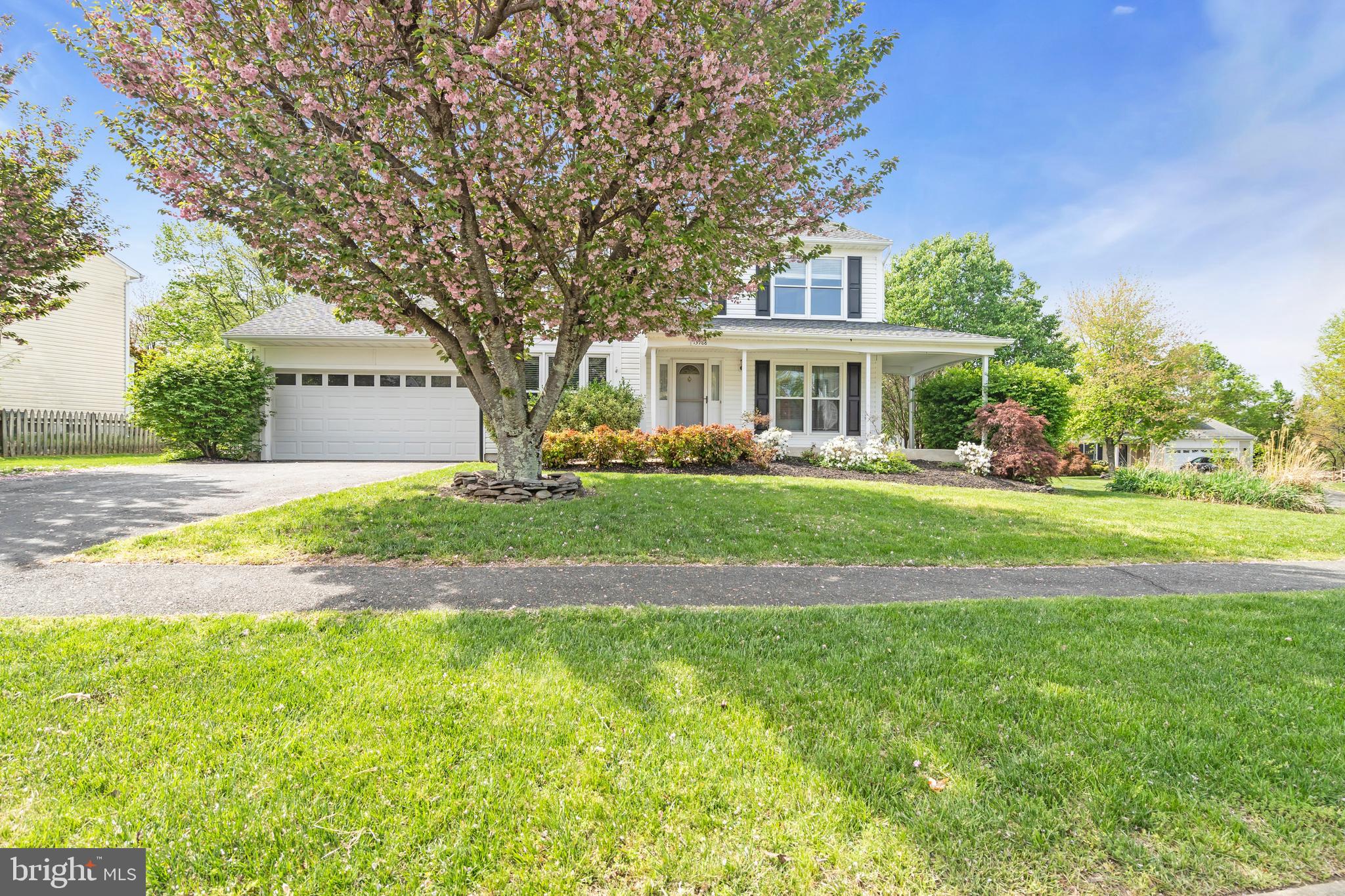 13988 Dancing Twig Drive Gainesville, VA 20155 - Photo 3 of 62 a front view of a house with a garden and trees