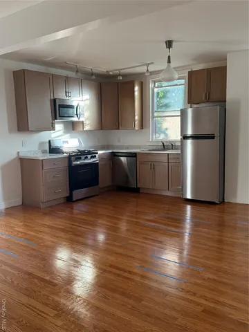 a kitchen with granite countertop a refrigerator and a stove top oven