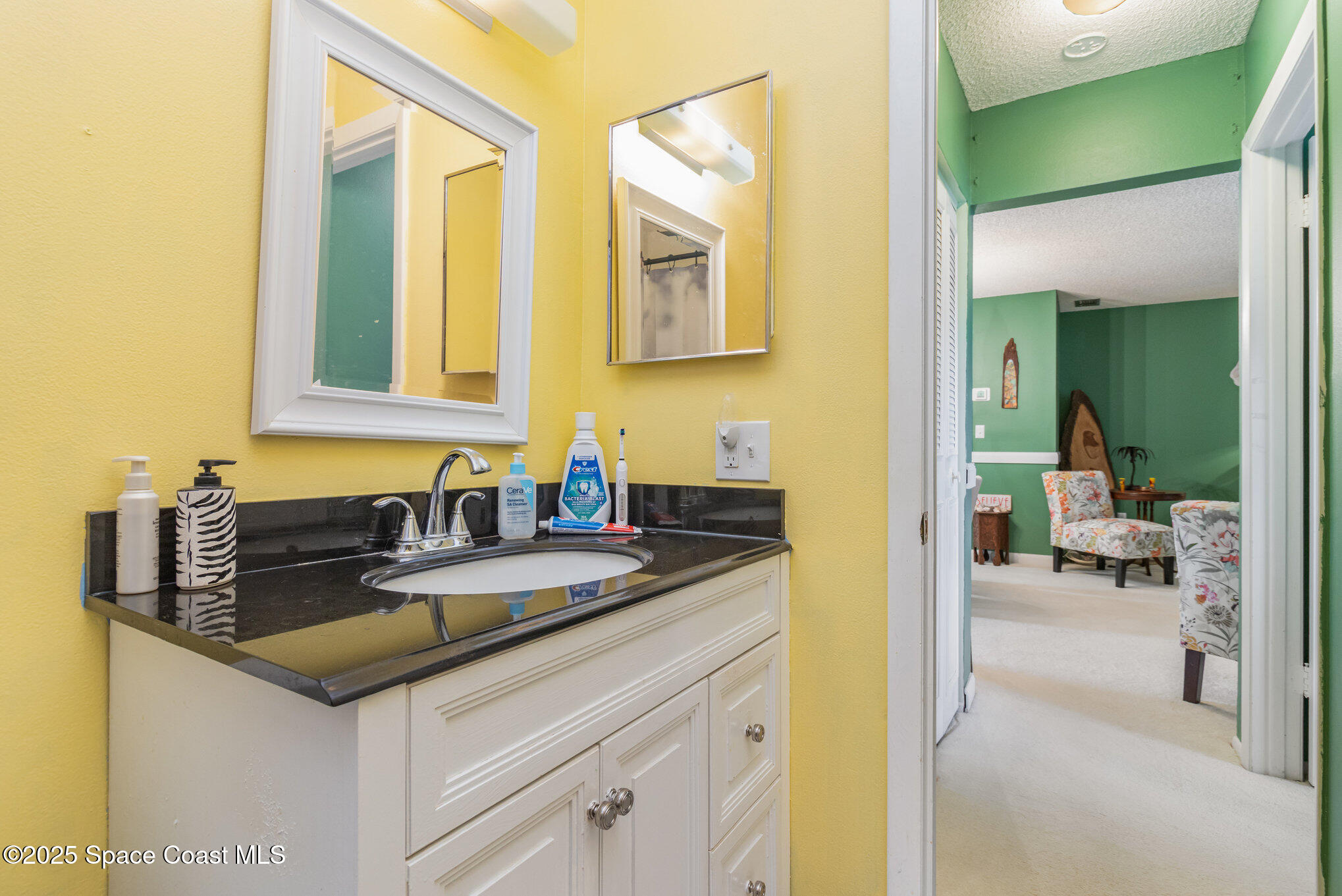 415 School Road, Unit 70 Indian Harbour Beach, FL 32937 - Photo 12 of 16 a bathroom with a granite countertop sink and a mirror