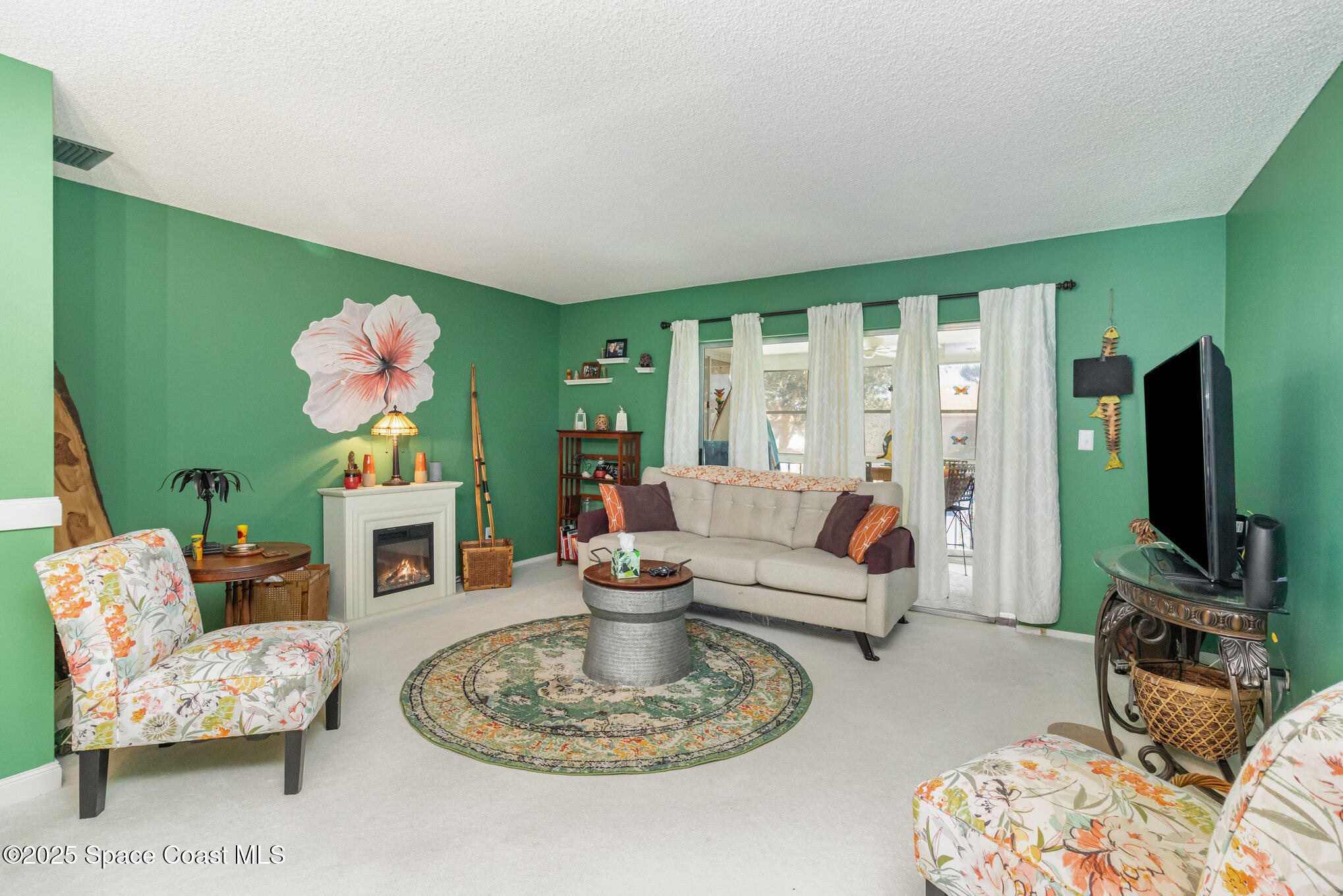 415 School Road, Unit 70 Indian Harbour Beach, FL 32937 - Photo 4 of 16 a living room with fireplace furniture and a flat screen tv