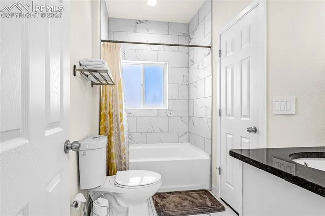 a bathroom with a granite countertop sink toilet and shower