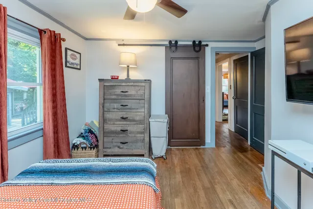 a view of a hallway with wooden floor and closet