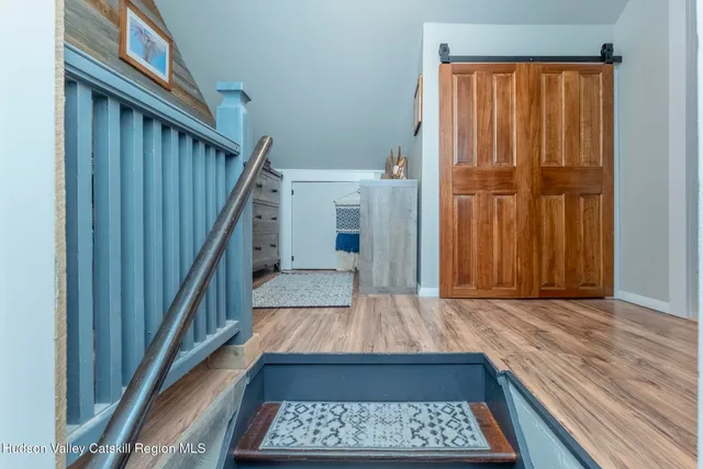 a view of a hallway with wooden floor and staircase